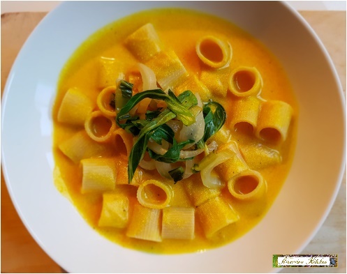 pasta with pumpkin-based sauce and steamed greens